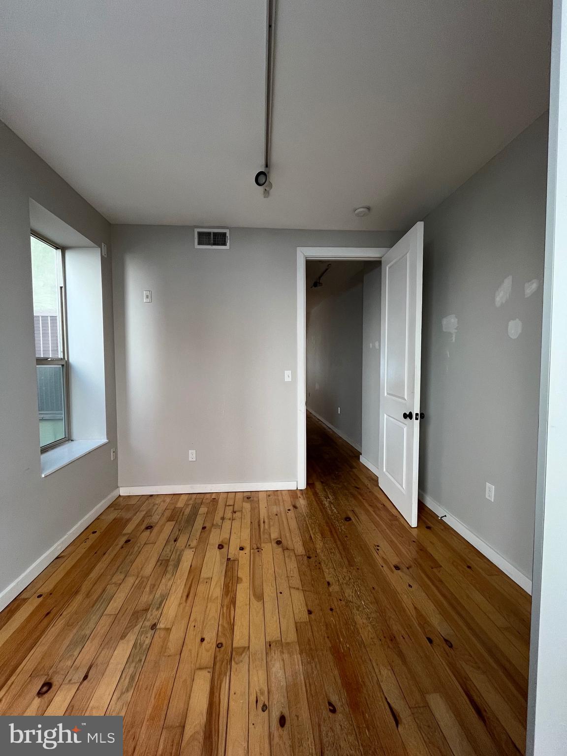 1208 North 4th Street, Unit 1 Philadelphia, PA 19122 - Photo 5 of 10 wooden floor in an empty room with a window