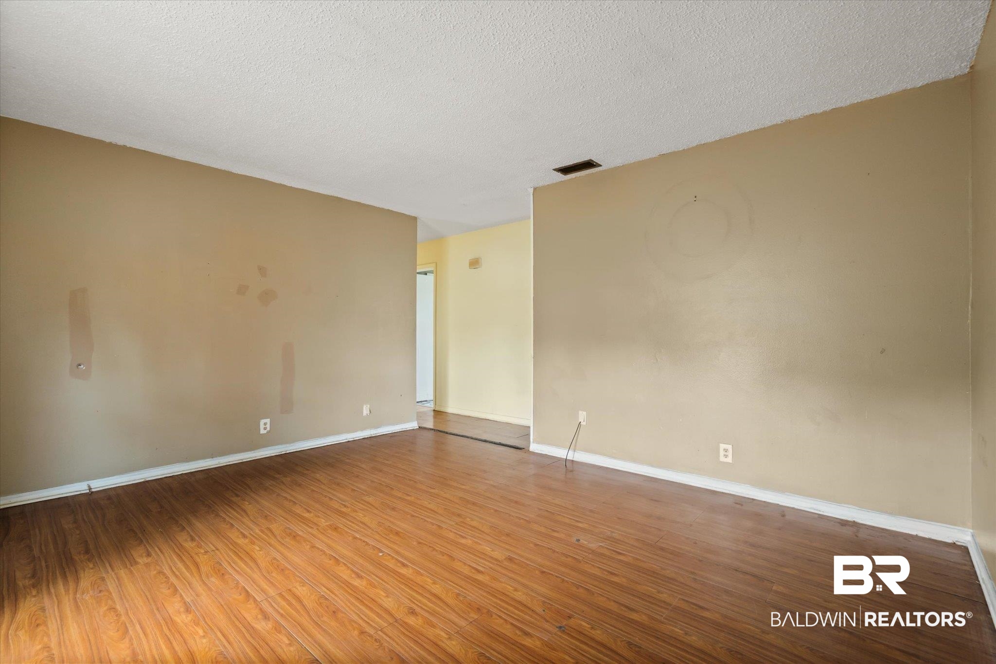 313 West 4th Avenue Foley, AL 36535 - Photo 3 of 20 Empty room featuring hardwood / wood-style flooring and a textured ceiling
