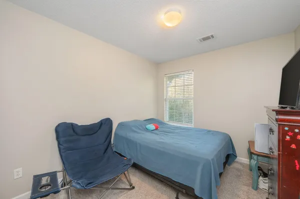 a bedroom with a bed and a chair