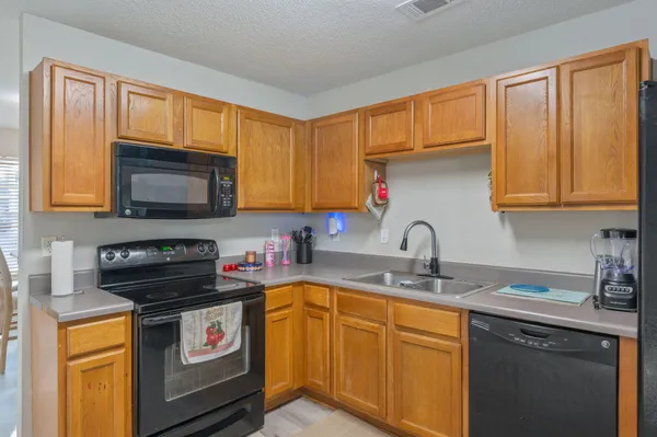 a kitchen with stainless steel appliances granite countertop a stove a sink dishwasher and cabinets with wooden floor