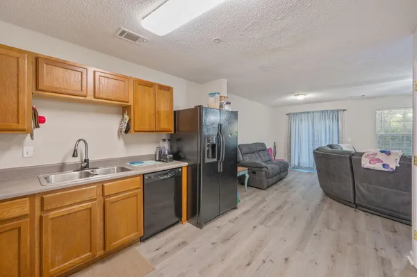 a kitchen with sink a refrigerator and cabinets