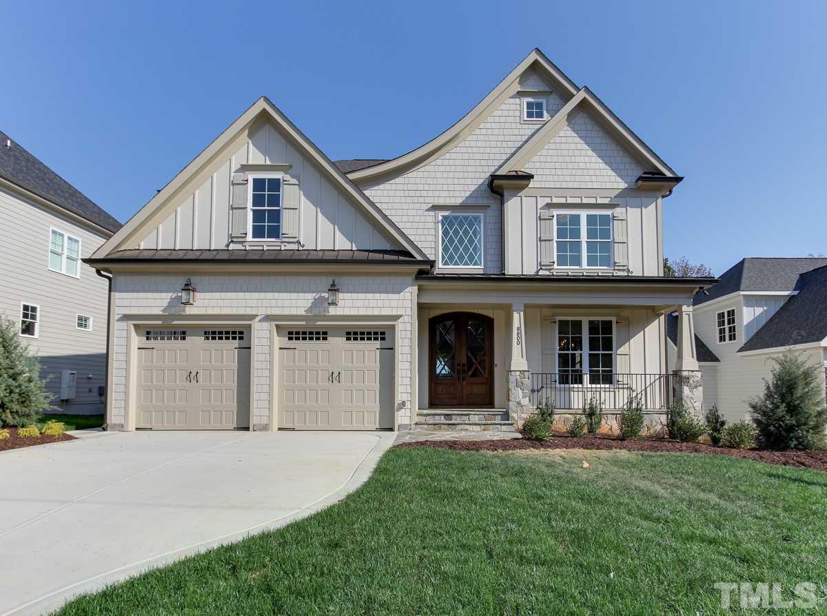 8800 Breeland Way Raleigh, NC 27613 - Photo 1 of 24 a front view of a house with a yard and garage