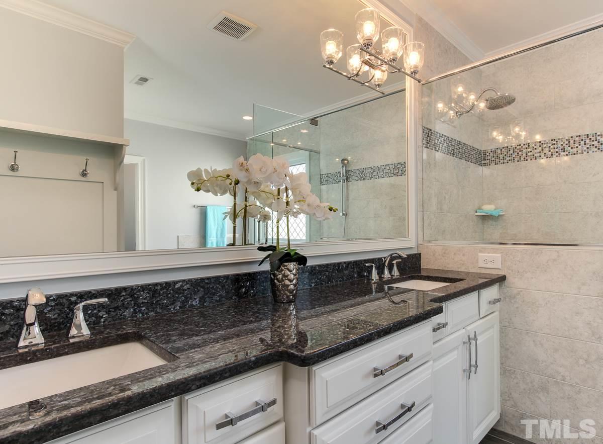 8800 Breeland Way Raleigh, NC 27613 - Photo 16 of 24 a sink with a granite countertop double vanity and a mirror