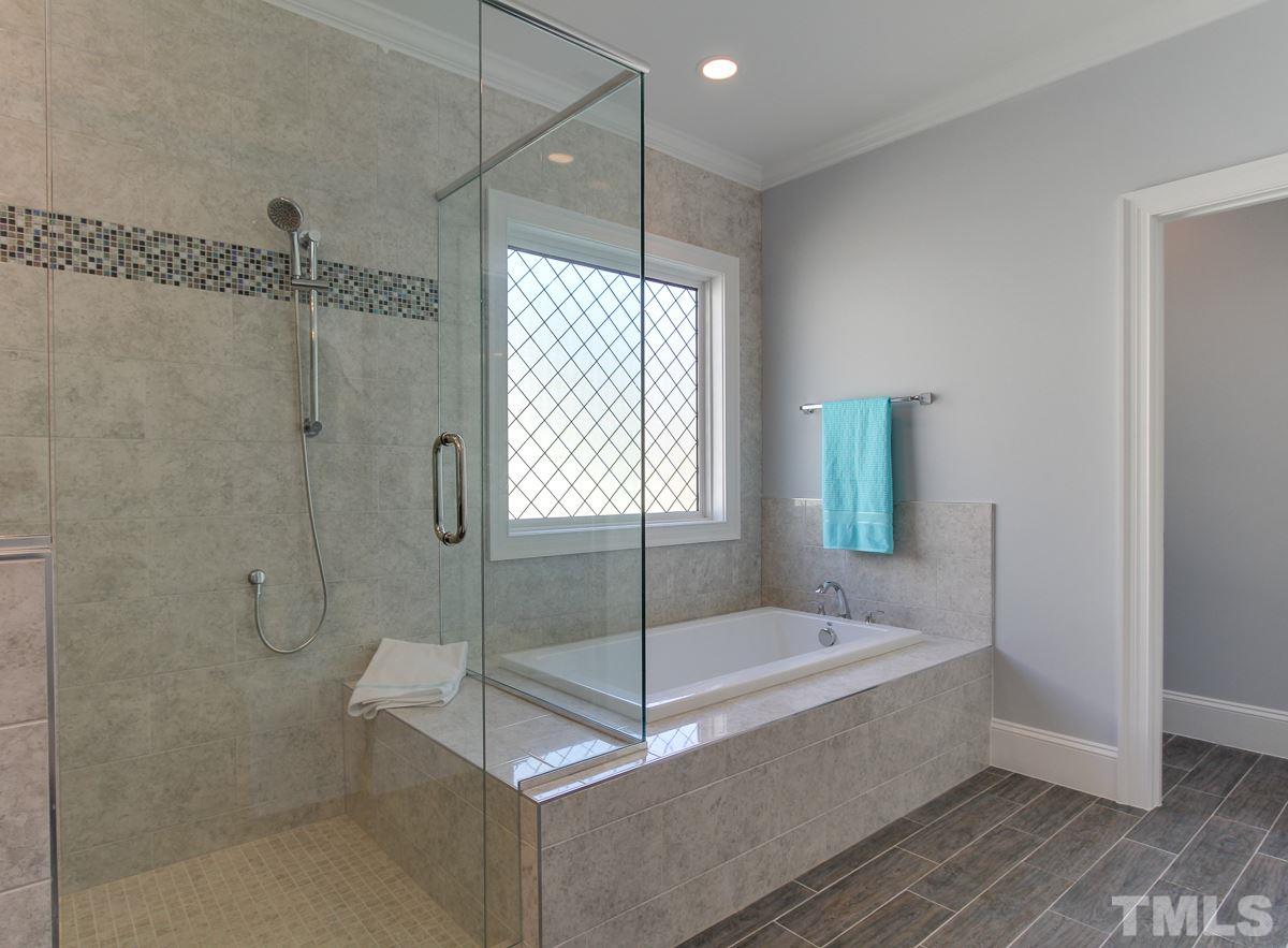 8800 Breeland Way Raleigh, NC 27613 - Photo 17 of 24 a bathroom with a tub and shower