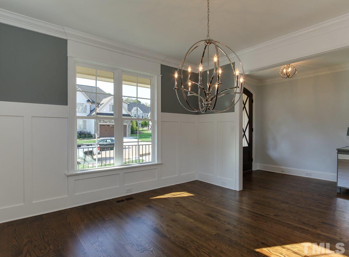 8800 Breeland Way Raleigh, NC 27613 - Photo 3 of 24 a room with wooden floor chandelier and windows