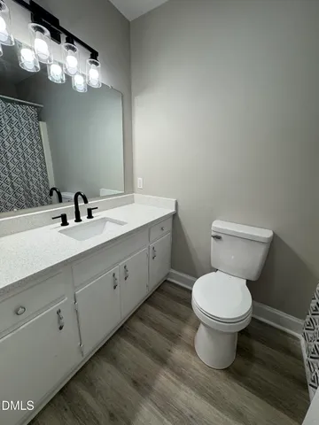 an empty room with wooden floor and ceiling fan