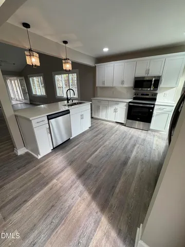 a view of a hallway with wooden floor and staircase