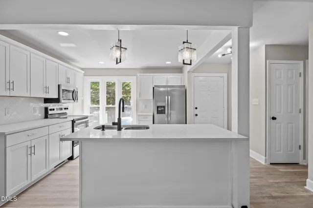 a large kitchen with a large counter top appliances and cabinets