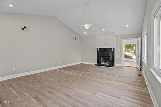 a kitchen with stainless steel appliances granite countertop a refrigerator a sink dishwasher and white cabinets with wooden floor