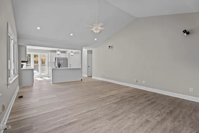 a view of an empty room with a window and wooden floor