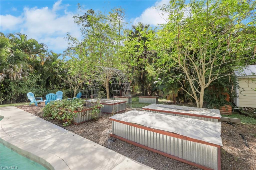 5092 Boxwood Way Naples, FL 34116 - Photo 25 of 48 Backyard space with raised garden beds to plant your own fruits and vegetables, firepit, tons of fruit trees throughout the yard, shed, workshop, chicken coop, guest house, and so much more