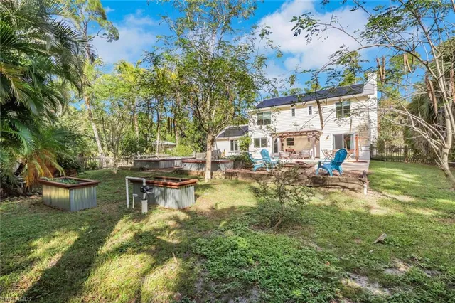 a view of a house with a yard and large tree