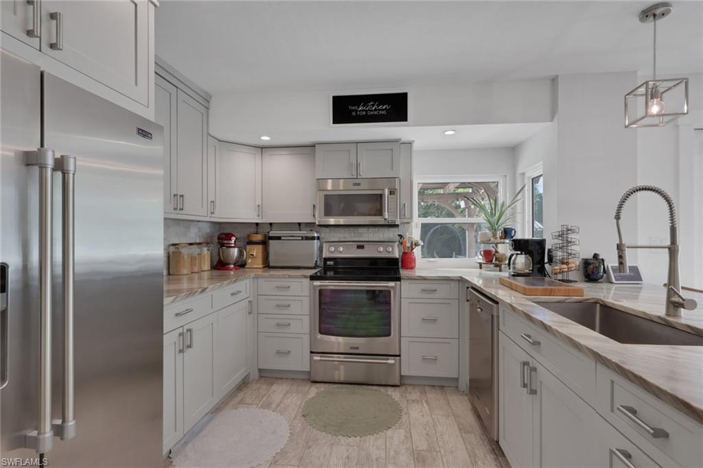 5092 Boxwood Way Naples, FL 34116 - Photo 7 of 48 Beautifully updated kitchen with Quartz Countertops, gray wood shaker cabinets, stainless steel appliances, and a large walk in pantry