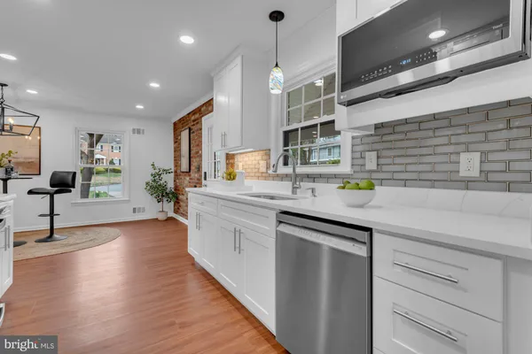 a kitchen with stainless steel appliances granite countertop a sink a stove and a wooden floors