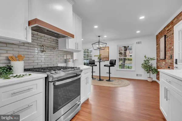 a kitchen with stainless steel appliances granite countertop a stove and a wooden floors