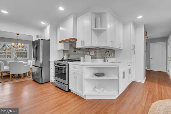 a kitchen with stainless steel appliances a stove a sink a refrigerator and cabinets