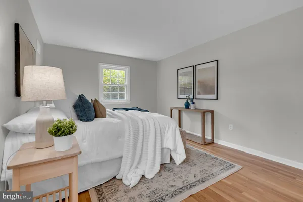 a bedroom with a bed lamp and a potted plant