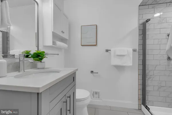 a bathroom with a sink a toilet and with mirror