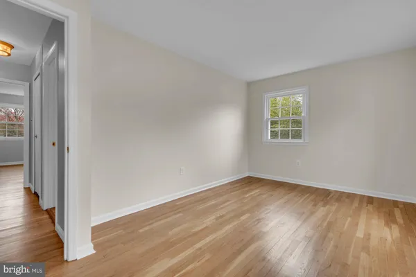 an empty room with wooden floor and a window