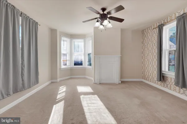 a view of a big room with windows and chandelier fan