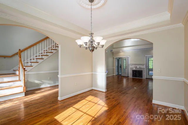 a view of a room with wooden floor staircase and a kitchen
