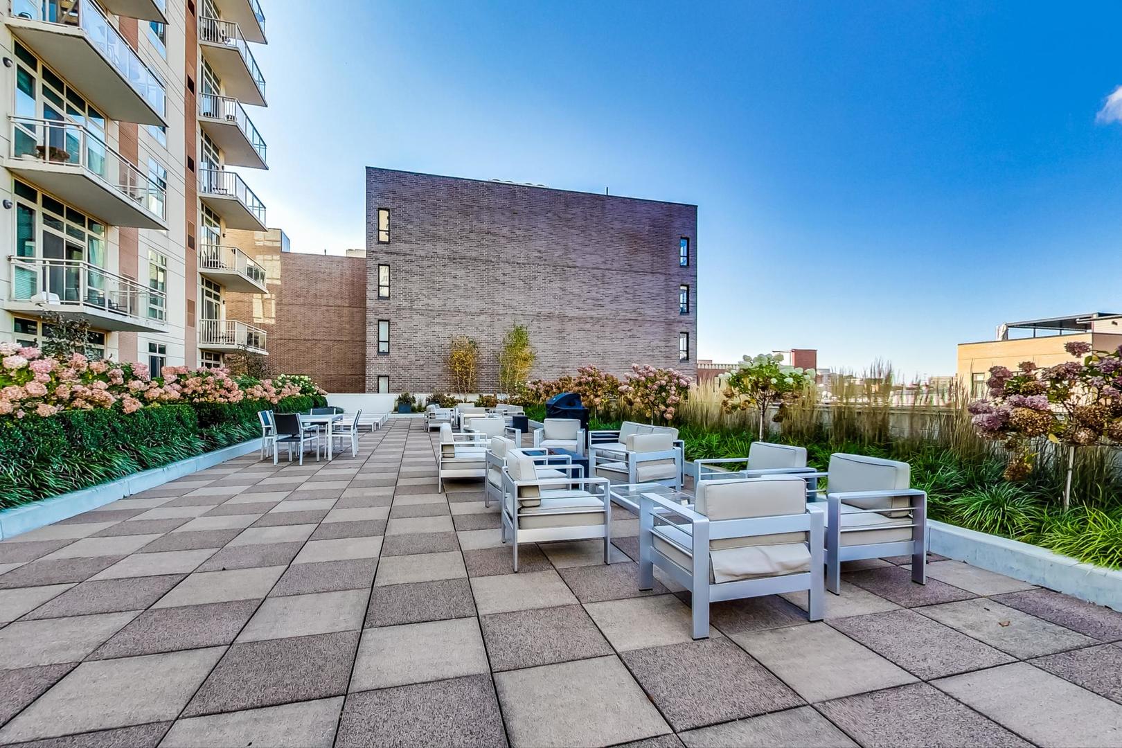 230 West Division Street, Unit 1307 Chicago, IL 60610 - Photo 26 of 33 a view of a patio with a table and chairs and potted plants