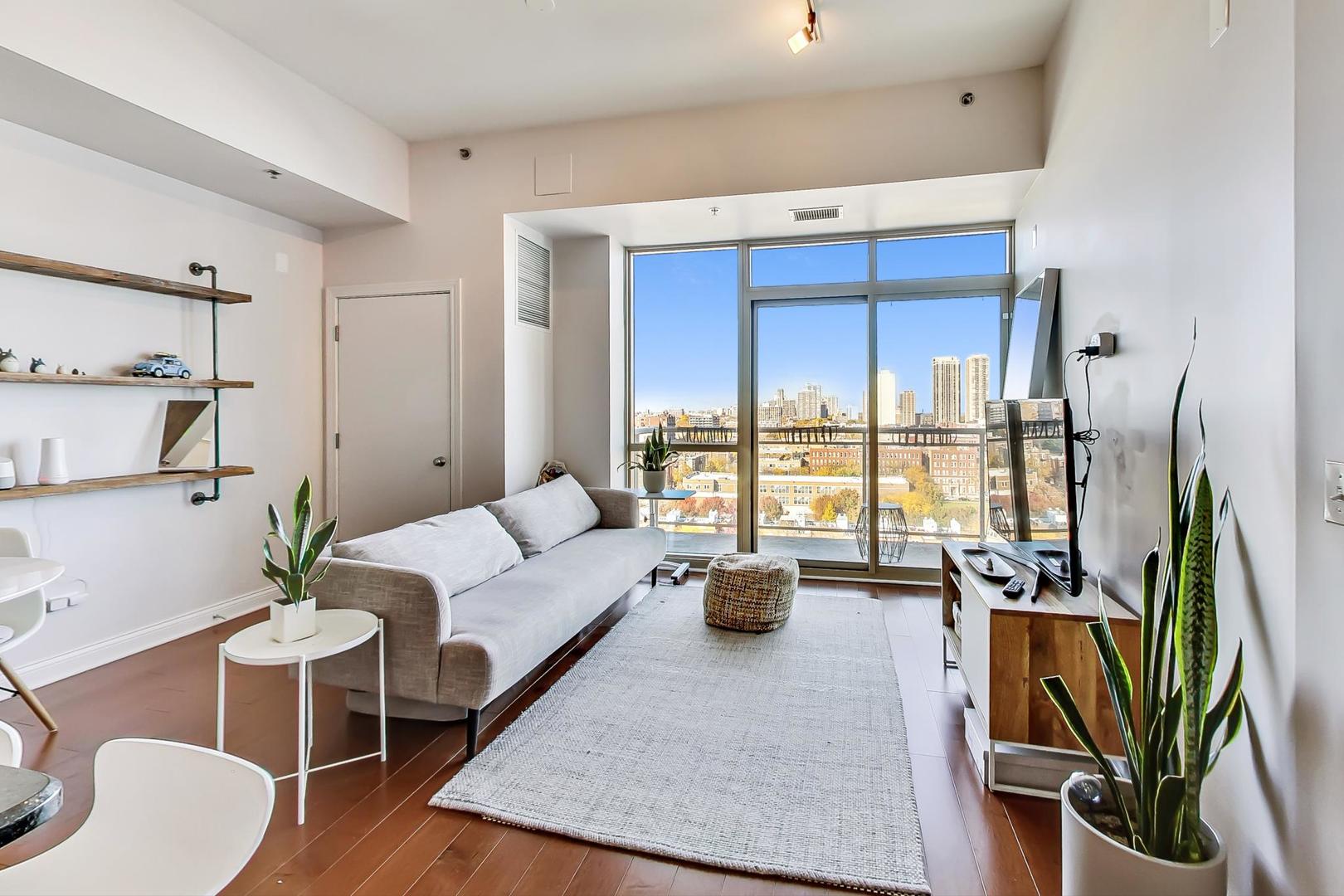 230 West Division Street, Unit 1307 Chicago, IL 60610 - Photo 4 of 33 a living room with furniture floor to ceiling window and potted plant