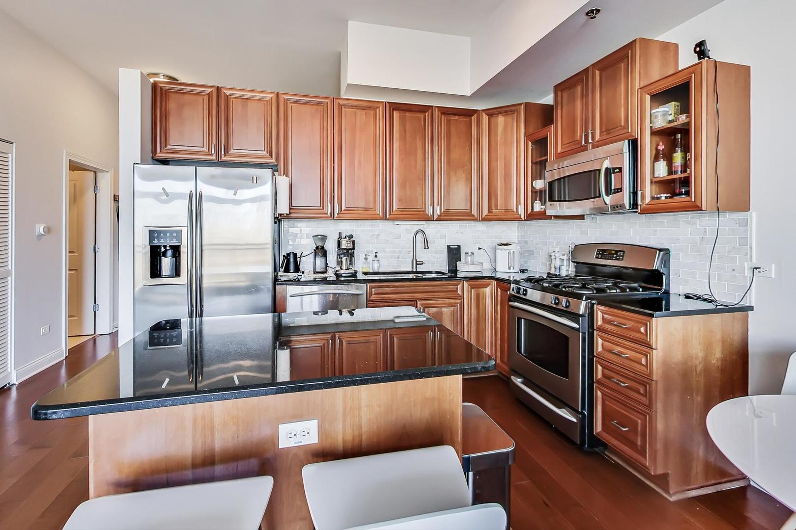 230 West Division Street, Unit 1307 Chicago, IL 60610 - Photo 9 of 33 a kitchen with stainless steel appliances granite countertop a refrigerator a stove top oven a sink and dishwasher