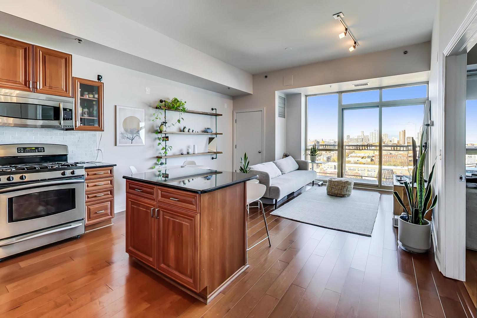 230 West Division Street, Unit 1307 Chicago, IL 60610 - Photo 10 of 33 a kitchen with stainless steel appliances kitchen island granite countertop a stove a sink and a refrigerator