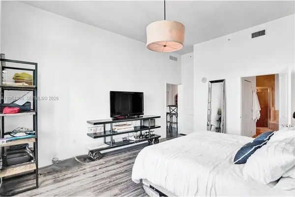 a bedroom with a bed and a flat screen tv
