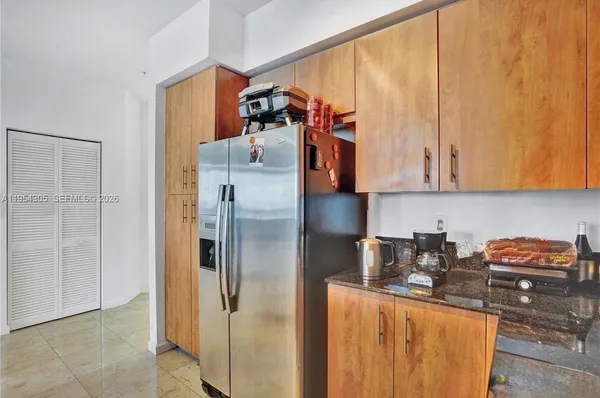 a kitchen with stainless steel appliances granite countertop a refrigerator and a stove