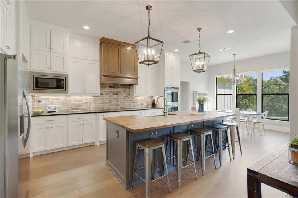 425 Ridgeview Road Sherman, TX 75092 - Photo 14 of 40 a kitchen with stainless steel appliances granite countertop stove a island a sink dishwasher a dining table and chairs with wooden floor