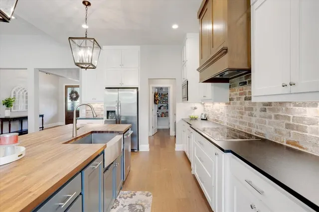 a kitchen with stainless steel appliances granite countertop lots of counter top space and wooden floor