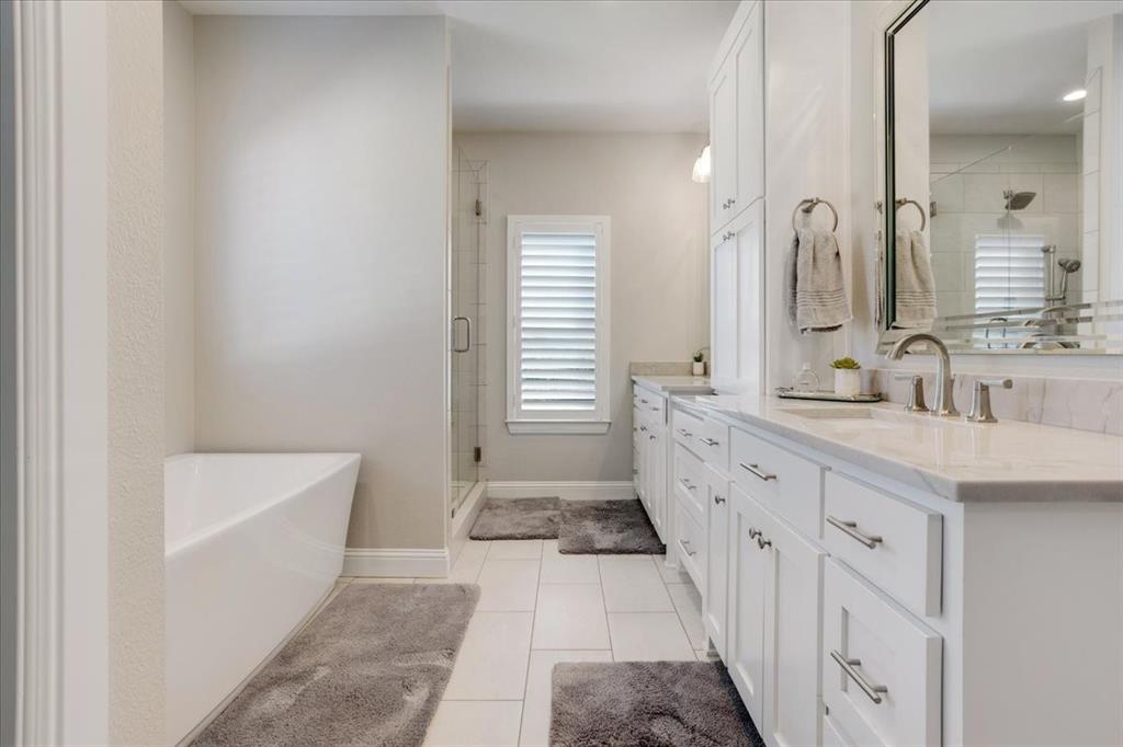 425 Ridgeview Road Sherman, TX 75092 - Photo 23 of 40 a bathroom with a double vanity sink a mirror and a bathtub