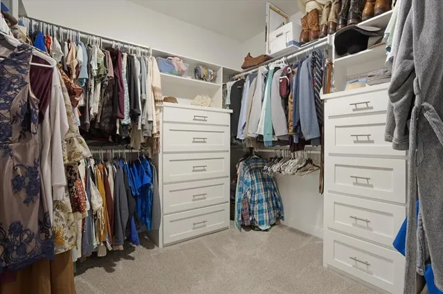 a view of walk in closet with clothes