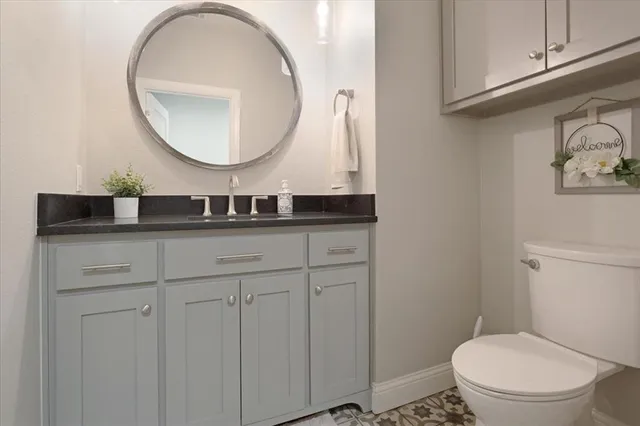 a bathroom with a toilet a sink and mirror
