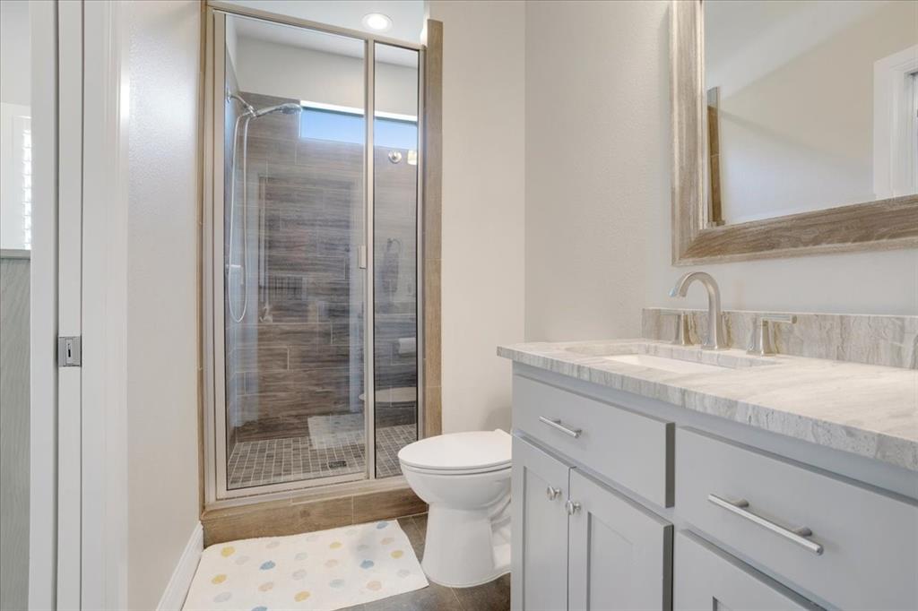 425 Ridgeview Road Sherman, TX 75092 - Photo 30 of 40 a bathroom with a granite countertop sink toilet a mirror and shower