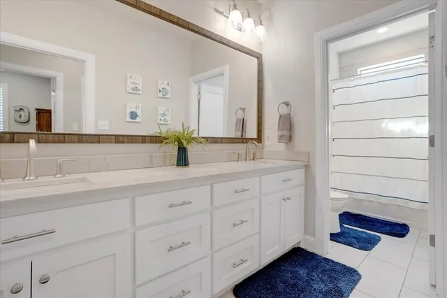 a bathroom with a double vanity sink a mirror and a shower