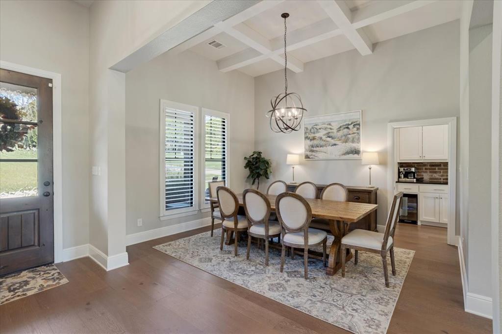 425 Ridgeview Road Sherman, TX 75092 - Photo 5 of 40 a dining room with wooden floor a chandelier a wooden table and chairs