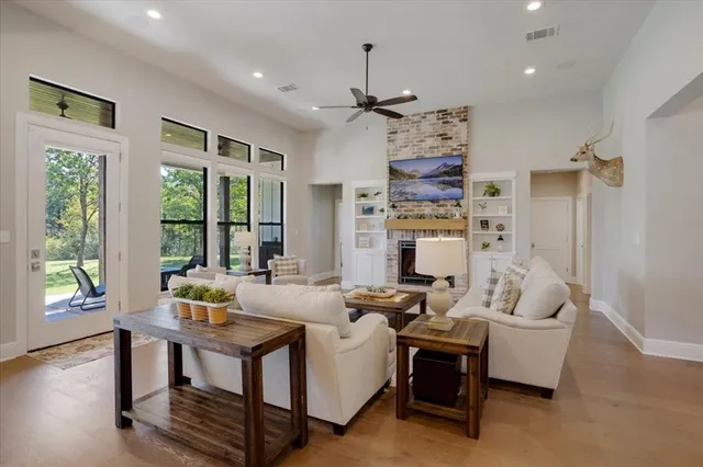 a living room with fireplace furniture and a large window