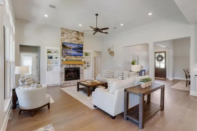 a living room with furniture a fireplace and a chandelier