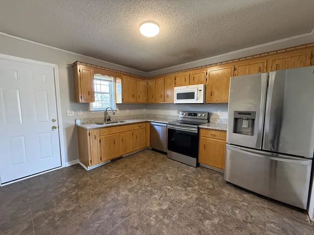 a kitchen with stainless steel appliances granite countertop a refrigerator sink and cabinets