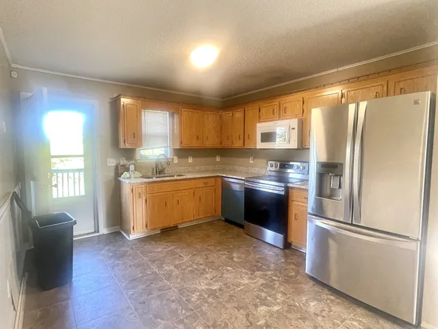 a kitchen with stainless steel appliances granite countertop a refrigerator sink and wooden floor