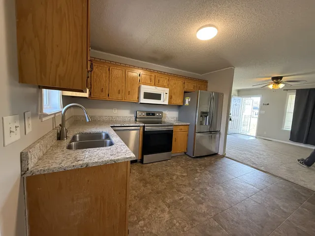 a kitchen with granite countertop a sink stove and refrigerator