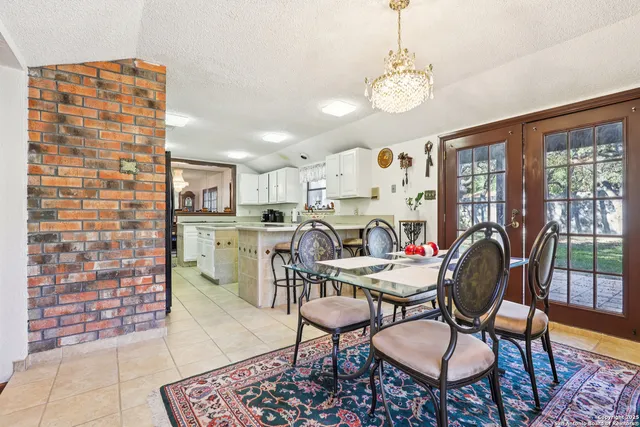 a dining room with furniture a rug a fireplace and a chandelier