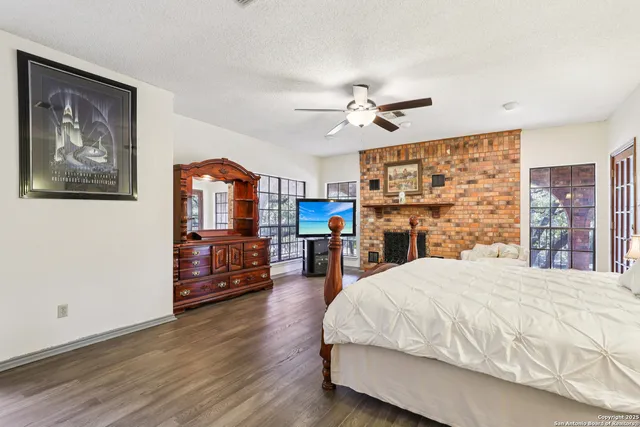 a spacious bedroom with a bed a dresser and wooden floor