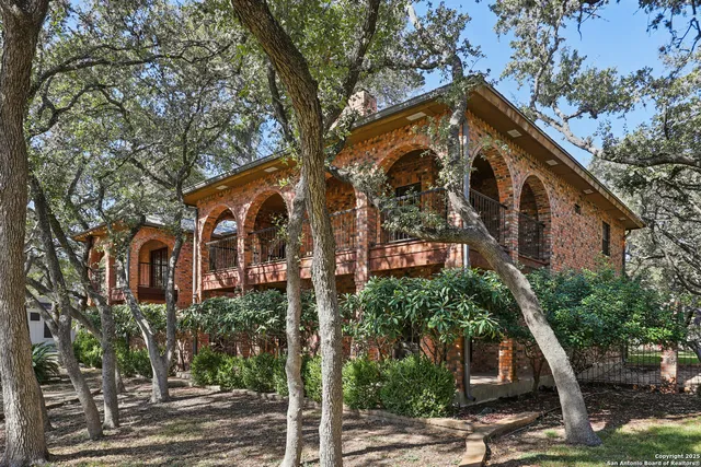 a front view of a house with a tree