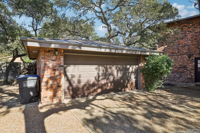 a backyard of a house with large trees and outdoor seating