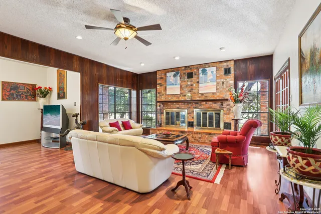 a living room with furniture fireplace and a large window