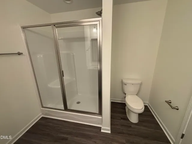 a bathroom with a toilet and a shower